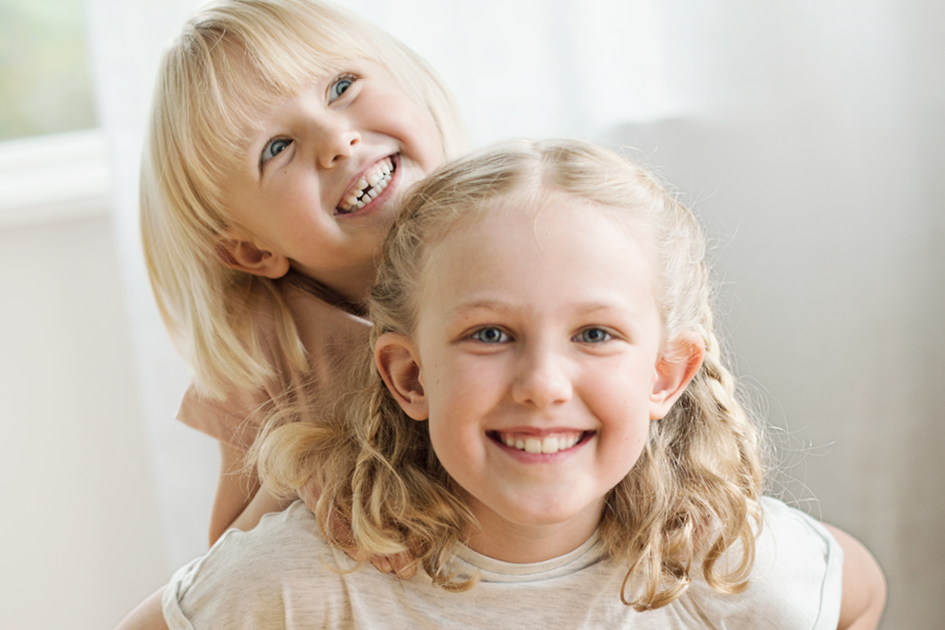 two little girls smiling brightly